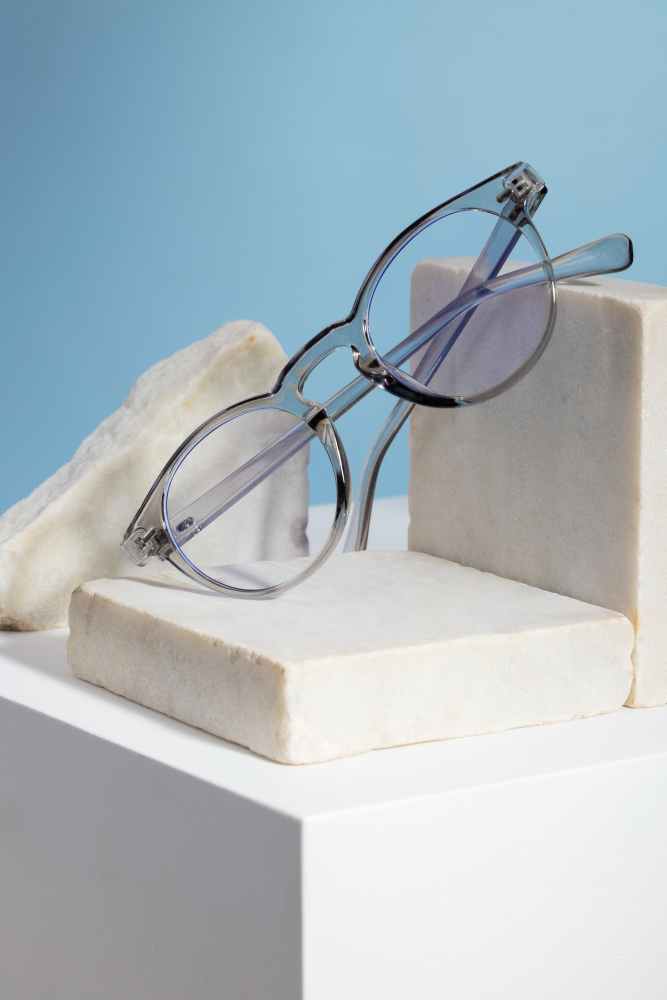 «Γυαλιά με μπλε φακούς πάνω σε ξύλινη επιφάνεια – ιδανικά για έντονη ηλιοφάνεια και ξεκούραστη όραση από το Phos Optical Store»